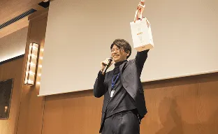 イベントでスピーチする社員