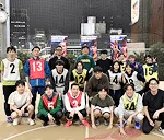 バスケのユニフォームを着た社員達が集合写真を撮っている様子